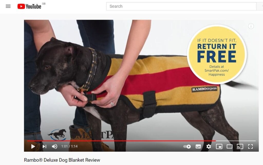 A screenshot of a video showing how to use a dog blanket.