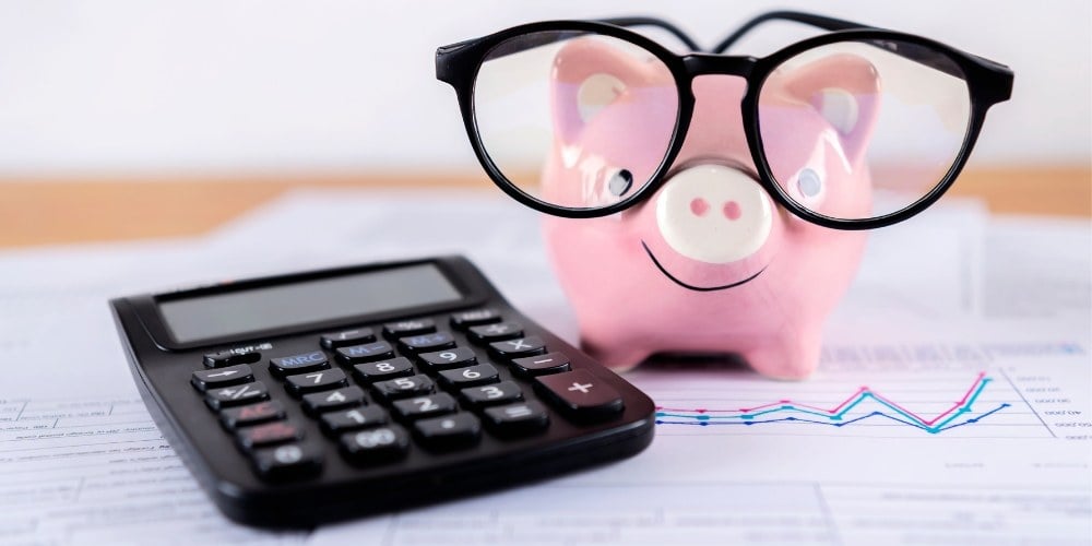 Uma calculadora e um cofrinho representando o orçamento